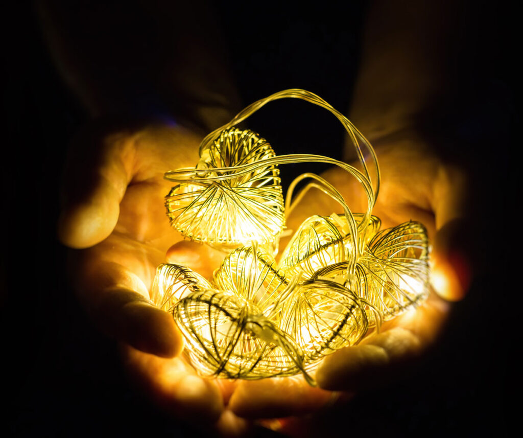 Warm glowing lights held in hands symbolizing hope, healing, emotional support, and trauma-informed therapy care at Christina Villatoro LMFT counseling practice